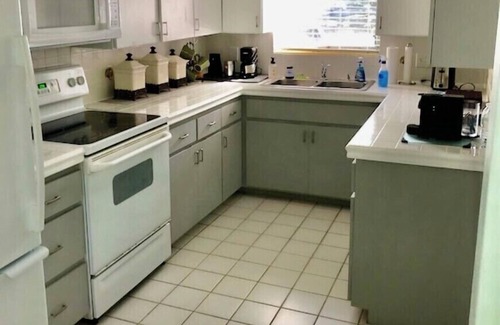 Central Beach House | A tropical retro bungalow secluded area with terrazzo flooring & heated pool.