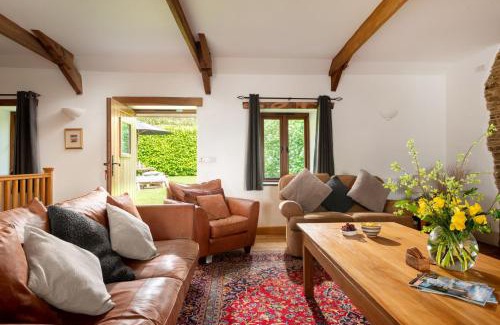 Widegates House | Corn Barn at East Trenean Farm -Luxury Cornish Barn Conversion sleeping 8 with hot tub, private garden, rural views and EV facilities