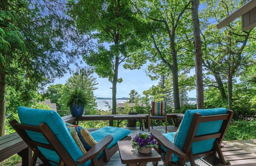 Lake Township House | Lake view cabin with a patio & a wood-burning stove