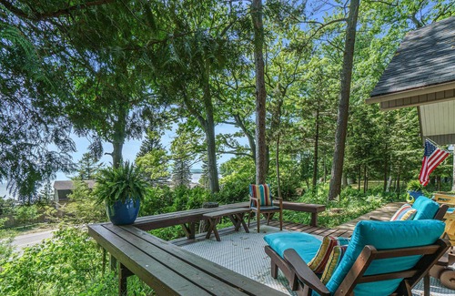 Lake Township House | Lake view cabin with a patio & a wood-burning stove