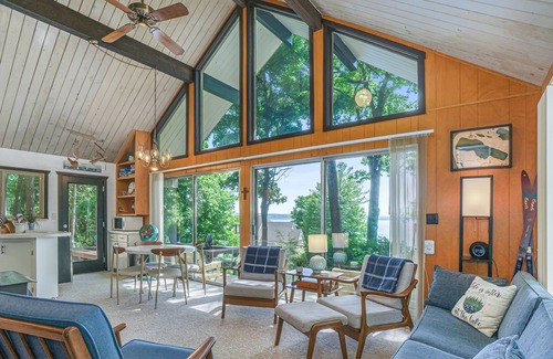 Lake Township House | Lake view cabin with a patio & a wood-burning stove