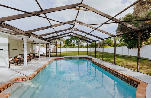 Palma Sola House | LUXE beach getaway 5mins from water. 3xKING BR, large heated pool + new playland