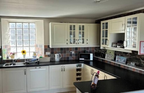 Bangor Cottage | Splash Cottage Beach house with sea touching back garden