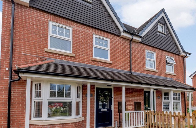 A superb modern house with a hot tub set under a gazebo with twinkling fairly lights.