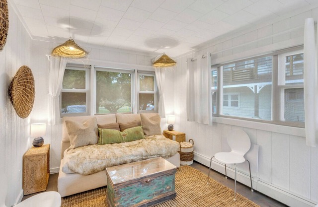 Bohemian-style hotel unit with ample natural light, a cozy seating area,.