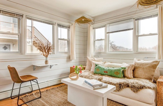 Bohemian-style hotel unit with ample natural light, a cozy seating area,.