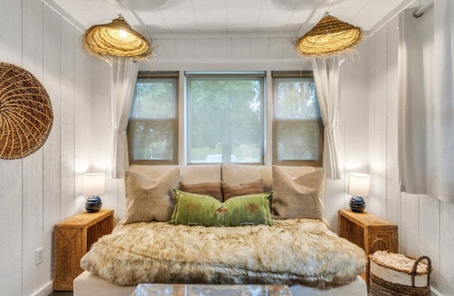 Bohemian-style hotel unit with ample natural light, a cozy seating area,.