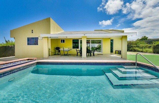 Escape to Happy Daze Villa, a sunny 3-bedroom, 2-bathroom vacation home in a charming yellow setting