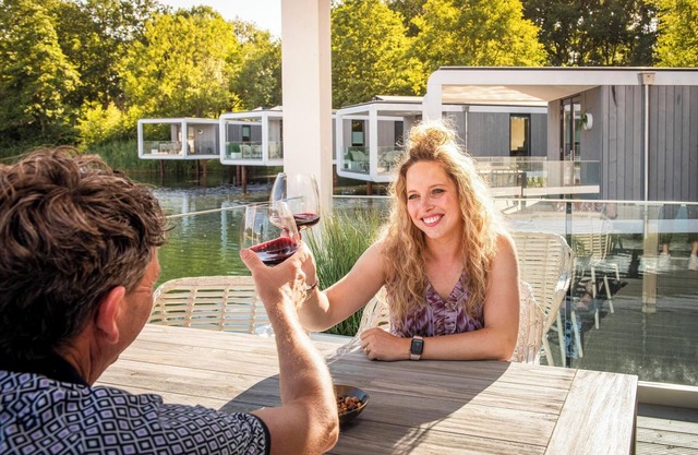 Stylish 5-person lodge with a terrace extending over the lake, luxury kitchen, walk-in shower and air conditioning.