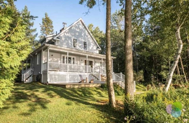 Superbe Cottage on the lake, surrounded by trees and mountains.
