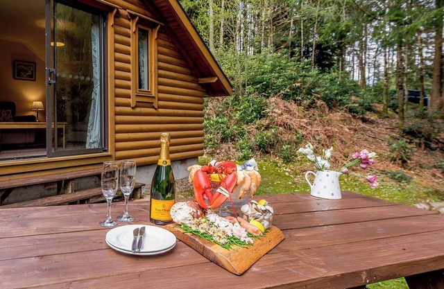 Timber lodge set in an elevated position with views of the lake.