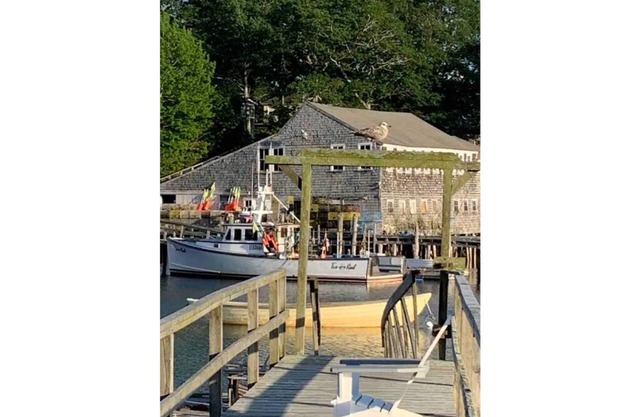 Vintage cabin perched on edge of harbor with dock