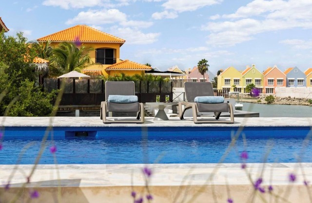 Waterfront villa with terrace, SUP boards, barbecue, and access to a shared swimming pool.