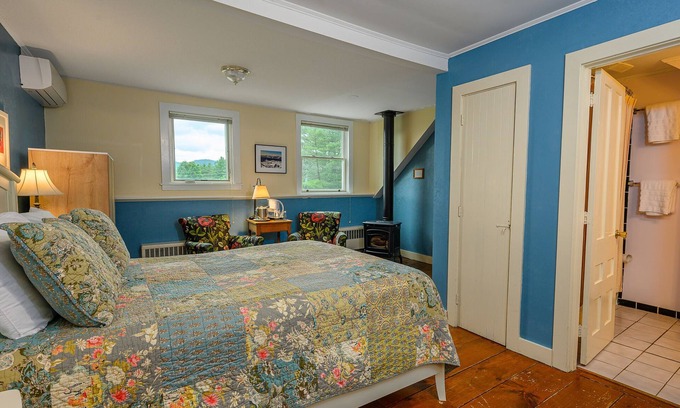 Stowe Bed & Breakfast | Comfortable room with queen bed, a stunning view of Mount Mansfield, sitting area and a parlor stove with full service breakfast included