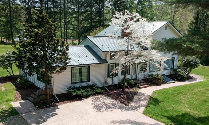 Hillsgrove House | Creek side house with fireplace and concrete driveway.