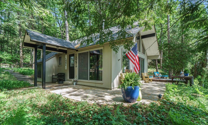 Lake Township House | Lake view cabin with a patio & a wood-burning stove