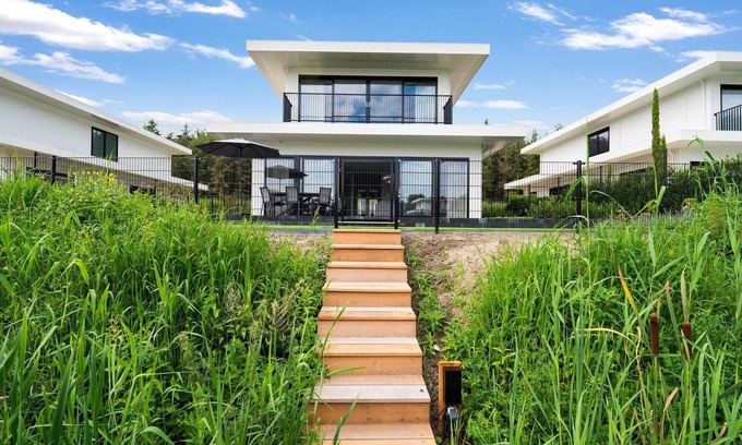 Zeewolde House | Luxury 6-person villa on the water with 3 bedrooms, 3 bathrooms, bath, balcony, spacious garden with swimming jetty and modern kitchen. Located at Villa Resort Harderwold near Harderwijk and the Veluwemeer.