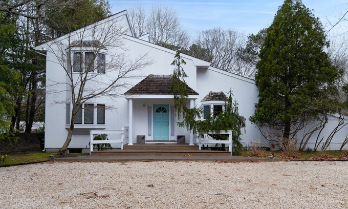 Quogue House | Post-Modern-style home with coastal-style bedrooms, an open-floor plan, a...